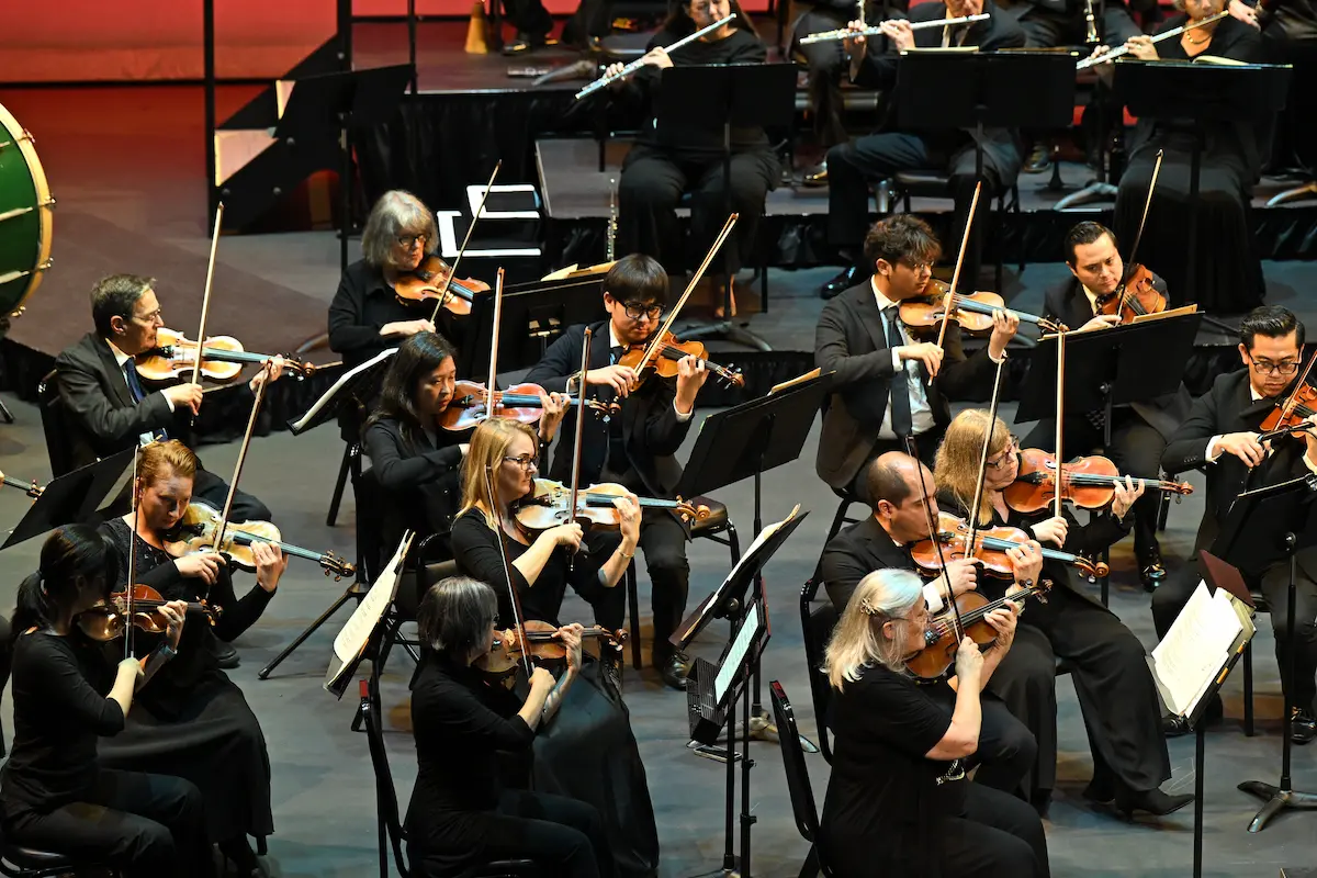 Members of the La Mirada Symphony perform The Star-Spangled Banner during a live orchestral concert.