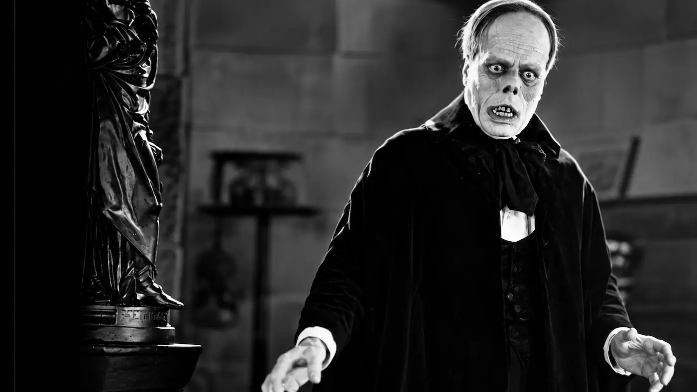 Digitally enhanced black-and-white recreation of Lon Chaney as the Phantom, wearing a dark cloak and displaying his skeletal makeup in The Phantom of the Opera (1925).